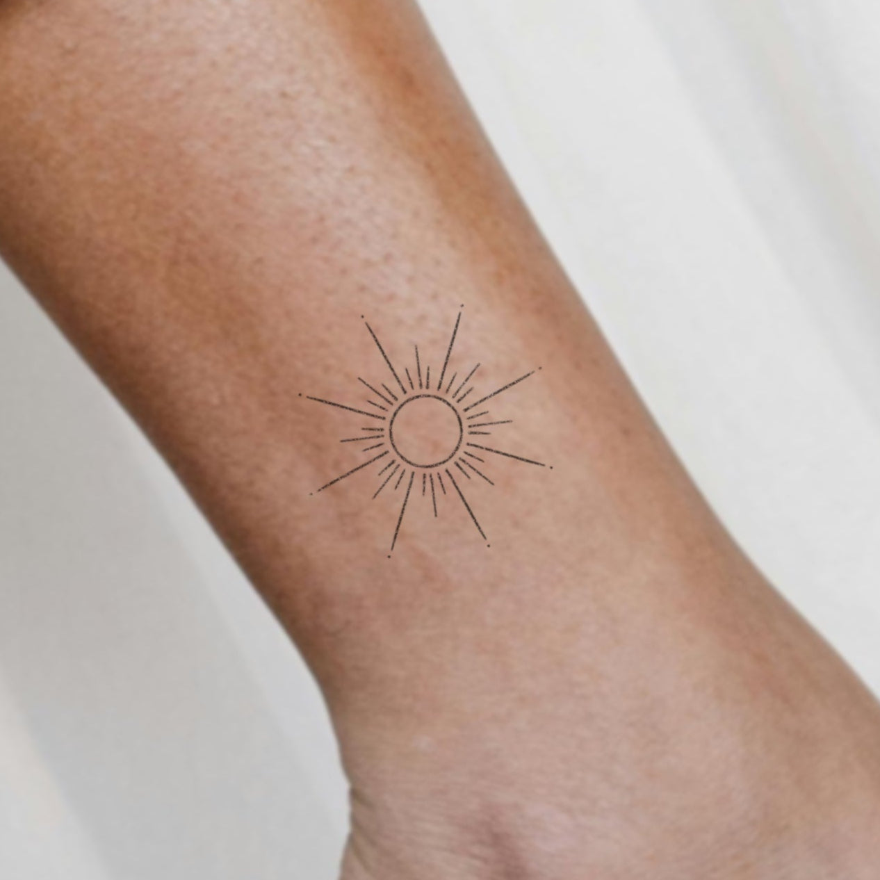 Kaïa – Tatouage Soleil minimaliste