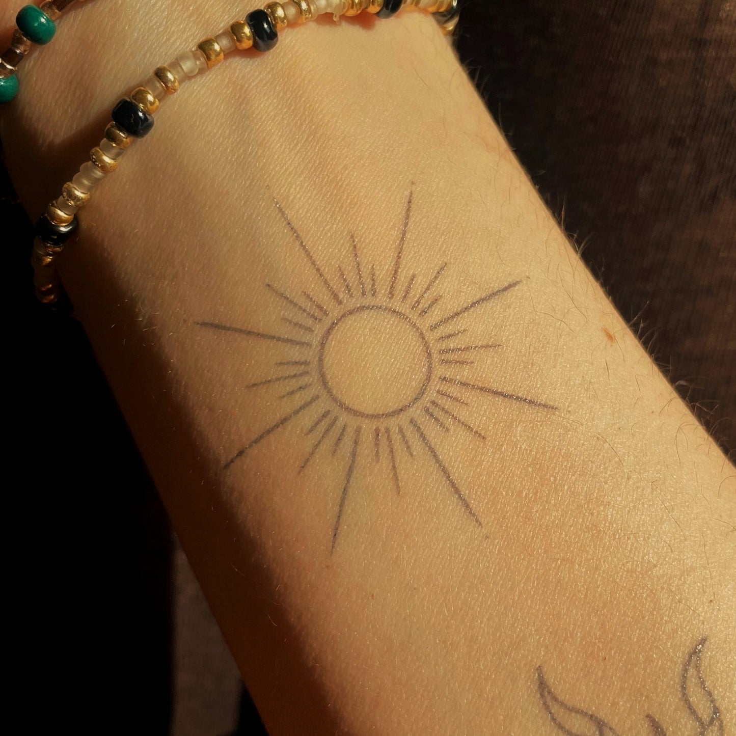 Kaïa – Tatouage Soleil minimaliste